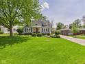 Inviting light blue home with a well-kept lawn and mature landscaping at 2011 Sheffield Ave, Anderson, IN 46011