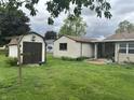 Lush backyard view with shed and covered patio area, ideal for outdoor relaxation at 211 Woodlane Dr, Columbus, IN 47201