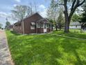 Inviting home showcasing a lush green lawn, mature trees and covered front entry at 2501 Mars Hill St, Indianapolis, IN 46241