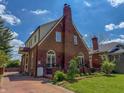 Beautiful brick home with a well-manicured lawn and a long driveway leading up to the property at 333 N Kenyon St, Indianapolis, IN 46219