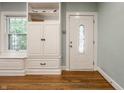 Bright entryway with hardwood floors, a white front door with decorative glass and a built-in storage at 357 N Kenyon St, Indianapolis, IN 46219