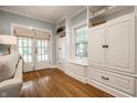 Cozy living area featuring hardwood floors, white built-in cabinets, and a view of the outdoors at 357 N Kenyon St, Indianapolis, IN 46219
