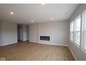 Large living room with modern fireplace, recessed lighting, and hardwood flooring at 3998 Bozeman Way, Bargersville, IN 46106