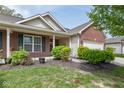 Charming brick home with a manicured lawn, lush landscaping, and a welcoming front porch at 410 Angelina Way, Avon, IN 46123