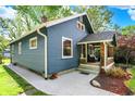 Lovely blue home featuring a covered front porch, neat landscaping, and a well-maintained exterior at 5015 Carrollton Ave, Indianapolis, IN 46205