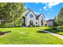 Well-maintained lawn and mature trees accent this house's facade, offering a serene curb appeal at 5521 Salem N Dr, Carmel, IN 46033