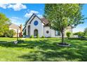 Inviting front yard with lush green grass and mature trees, showcasing the home's curb appeal at 5521 Salem N Dr, Carmel, IN 46033