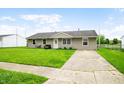 Single-story home with a well-kept lawn and paved driveway leading to the entrance at 605 Memorial Dr, Edinburgh, IN 46124