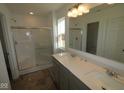 Well-lit bathroom with a double sink vanity, a large mirror, and a glass-enclosed shower, ready for customization at 6219 Medina Spirit Dr, Indianapolis, IN 46237