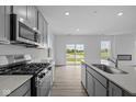 Modern kitchen with stainless steel appliances, granite counters, island, and an open floorplan at 6219 Medina Spirit Dr, Indianapolis, IN 46237