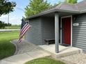Home entrance featuring a bright red front door, bench seating and an American flag at 7897 Moore Rd, Indianapolis, IN 46278