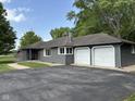Charming single-story home featuring a two-car garage, gray siding and a walkway leading to the front door at 7897 Moore Rd, Indianapolis, IN 46278