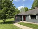 Charming home with gray siding, a red front door, and a walkway leading to the entryway at 7897 Moore Rd, Indianapolis, IN 46278