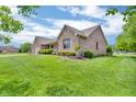 Brick home with a manicured front lawn and a covered porch, set against a blue sky with fluffy clouds at 802 Echo Trl, Martinsville, IN 46151