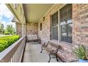 Inviting brick porch with a porch swing, bench seating, and natural light at 802 Echo Trl, Martinsville, IN 46151