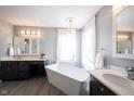 Luxurious bathroom featuring a freestanding tub, double vanities, and elegant lighting fixtures at 8970 Buttercup Ct, Noblesville, IN 46060