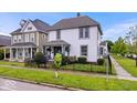Charming two-story home with a well-manicured front yard, landscaping, and a black wrought iron fence at 925 S State Ave, Indianapolis, IN 46203