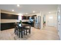 Modern kitchen with stainless steel appliances, dark cabinetry, and a dining table at 10107 Camp Creek Way, Indianapolis, IN 46229