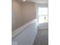 Upstairs hallway filled with natural light from a window, showcasing modern finishes and neutral carpet at 10126 Redwood Peak Ln, Indianapolis, IN 46259