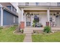 Welcoming front porch featuring vibrant potted plants, offering a cozy and inviting entrance to this charming home at 1021 Harlan St, Indianapolis, IN 46203