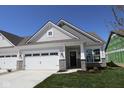 Charming home featuring a two-car garage with stone accents and classic carriage doors at 10544 Maidenhair Dr, Indianapolis, IN 46239
