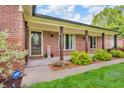 Charming brick home featuring a welcoming front porch, wood columns, and tasteful landscaping at 10559 Rolling Springs Dr, Indianapolis, IN 46234
