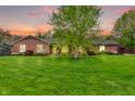 Lovely brick home with lush green lawn and healthy landscaping, perfect for outdoor enjoyment at 10559 Rolling Springs Dr, Indianapolis, IN 46234