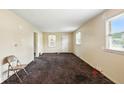Empty living room featuring natural light from windows and neutral carpet at 1235 N Grant Ave, Indianapolis, IN 46201