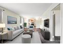 Bright living room featuring neutral walls, carpet, and views to the kitchen at 1235 N Grant Ave, Indianapolis, IN 46201