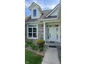Inviting entrance with a classic white door, decorative sidelights and a well-kept garden at 12551 Hawks Landing Dr, Fishers, IN 46037