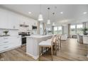 Bright kitchen boasts white cabinets, stainless steel appliances, and a large island with bar stool seating at 13324 Roundtop Rd, Noblesville, IN 46060
