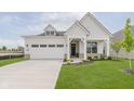 Charming home with white siding, a welcoming front porch, manicured lawn, and an attached two-car garage at 13355 Seven Springs Ln, Noblesville, IN 46060