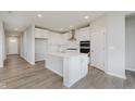 Bright, open kitchen featuring a large center island, stainless steel appliances, and plenty of cabinet space at 13355 Seven Springs Ln, Noblesville, IN 46060