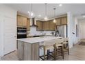 Bright eat-in kitchen features stainless appliances, wood cabinetry and pendant lighting at 13355 Seven Springs Ln, Noblesville, IN 46060