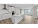 Bright kitchen features white cabinets, stainless steel appliances, a large island, and hardwood floors at 13355 Seven Springs Ln, Noblesville, IN 46060