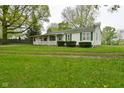 Quaint single story home with a long front porch and green shutters at 1425 E Us Highway 40, Clayton, IN 46118