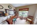 Cozy office with natural light, wood desk, and wicker chair by the window at 18247 Kinder Oak Dr, Noblesville, IN 46062