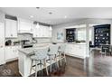 Bright kitchen with granite countertops, white cabinetry, a center island with seating, and stainless steel appliances at 18820 Wychwood Pl, Noblesville, IN 46062