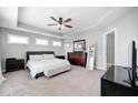 Serene bedroom with neutral tones, tray ceiling, plush carpet, and ample natural light from multiple windows at 18820 Wychwood Pl, Noblesville, IN 46062