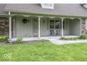 Inviting covered porch with seating, perfect for relaxing and enjoying the peaceful surroundings at 3134 W Hickory Woods Dr, Greenfield, IN 46140