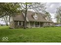 Lovely home with a well-maintained lawn and inviting covered porch, offering a warm welcome at 3134 W Hickory Woods Dr, Greenfield, IN 46140