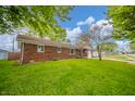 Exterior view of a brick home with a lush green lawn and mature trees in a residential neighborhood at 331 W 5Th St, Lapel, IN 46051