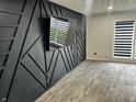 Stylish living room featuring a modern black accent wall, neutral flooring, and ample natural light at 3401 W Kessler Blvd N Dr, Indianapolis, IN 46222