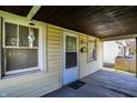 Cozy porch area with painted wood flooring and 'Beware of Dog' sign, adding charm and a touch of humor at 3609 N Keystone Ave, Indianapolis, IN 46218