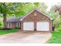 Spacious driveway leading to a two-car garage with traditional red brick exterior and trimmed in white at 378 Turnberry Ct, Avon, IN 46123