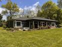 Charming single-story home with well-manicured lawn, mature trees, and a welcoming front porch at 406 Frst Pk N Dr, Greenwood, IN 46142