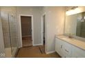 Modern bathroom featuring a glass door shower, vanity with light countertop and a view to a walk-in closet at 4076 Berry Chase Blvd, Greenwood, IN 46143