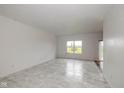 Bright living room featuring neutral walls, large windows and stylish marble floors at 4752 Chip Shot Ln, Indianapolis, IN 46235