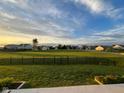 Spacious fenced backyard with grass and neighborhood view, with a lovely blue sky at 505 Shallowroot Ln, Sheridan, IN 46069