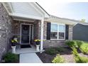 Inviting front porch showcasing brickwork, decorative plants, and a welcoming entrance at 509 Tulip Tree Dr, Lapel, IN 46051
